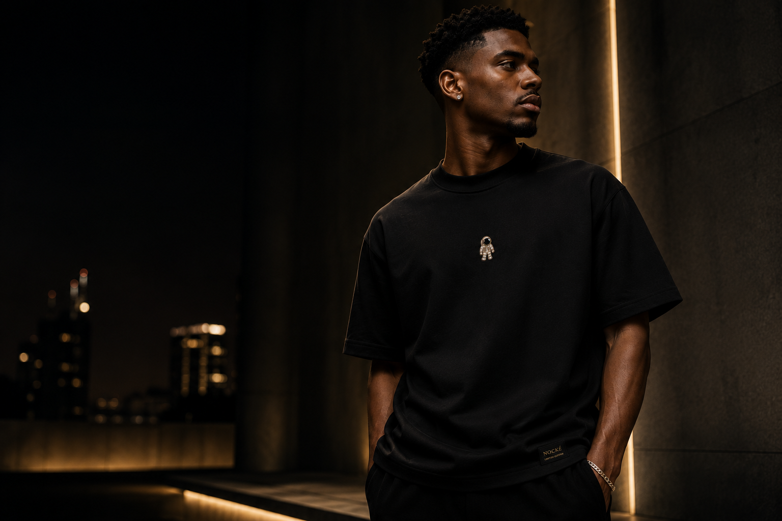 Model wearing a black NOCKÉ tee in a night editorial campaign